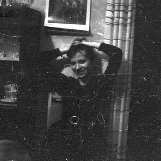 Vintage black-and-white photo of person laughing indoors.