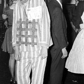 Man in striped concentration camp attire at event.