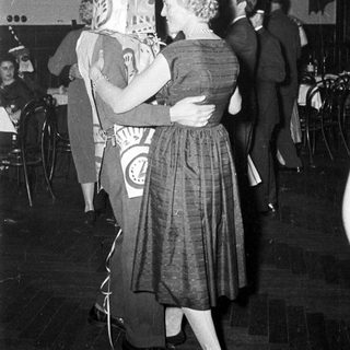Costumed couple dancing at a festive event.