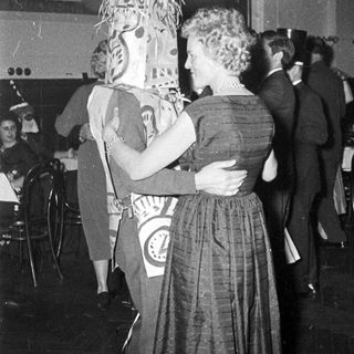 Costumed couple dancing at a festive event.