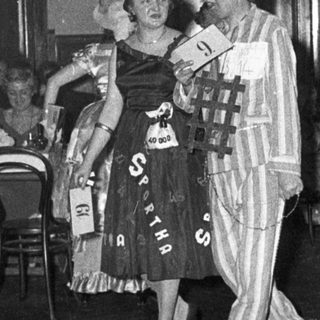 Costumed party guests dancing indoors.