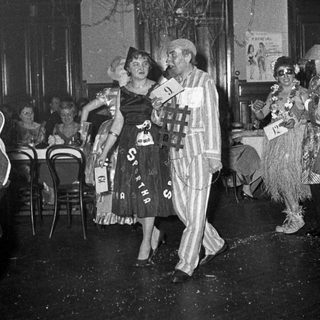 Costumed party guests dancing indoors.