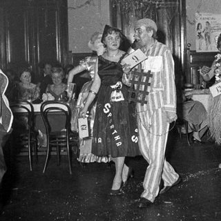 Costumed party guests dancing indoors.