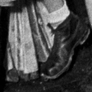 Costumed party attendees in 1940s-style masks and themed outfits.