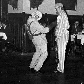 Two people dancing at a festive indoor event.