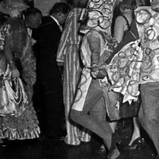 Costumed dancers performing in indoor festive event.
