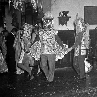 Costumed dancers performing in indoor festive event.