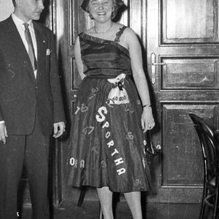Man and woman in formal attire at event.