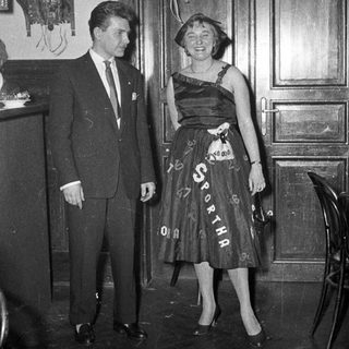 Man and woman in formal attire at event.