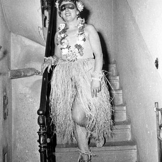 Person in traditional Polynesian-style hula dress on stairs.