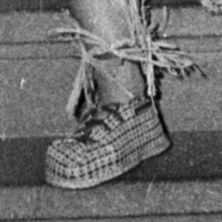 Person in traditional Polynesian-style hula dress on stairs.