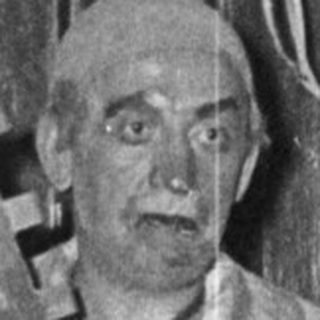 Prisoner in striped uniform holding gallows prop.