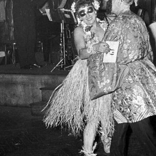 Two performers in playful, vintage costumes dancing on stage.