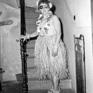 Woman in 1950s-style hula dress on staircase.