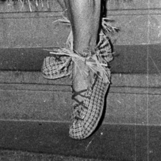 Woman in 1950s-style hula dress on staircase.