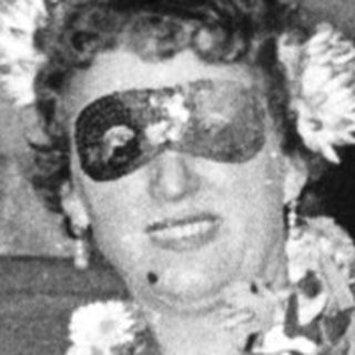 Woman in 1950s-style hula dress on staircase.