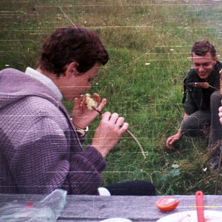 People enjoying outdoor picnic with food.