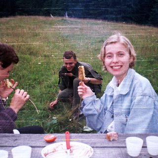 People enjoying outdoor picnic with food.