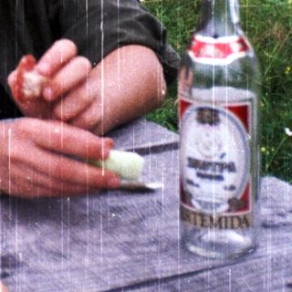 Man eating bread outdoors during light rain.