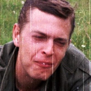 Man eating bread outdoors during light rain.