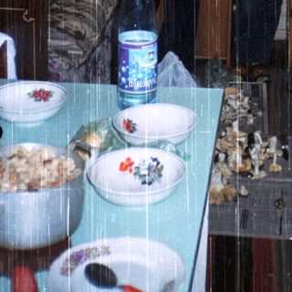 Three people standing indoors in a tent-like structure.