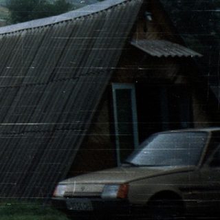 Man pointing near tilted solar panel in rural area.