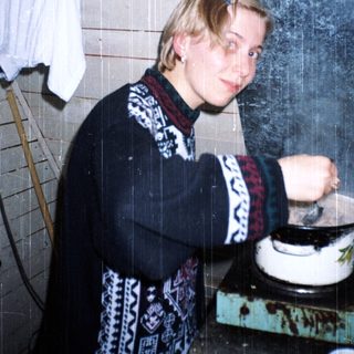 Person cooking in a kitchen with steamy window.