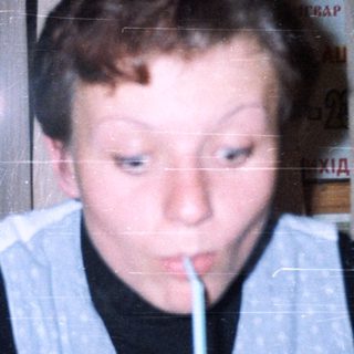 Boy drinking through a straw indoors.