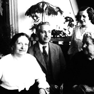 Four individuals posing indoors, mid-20th century.