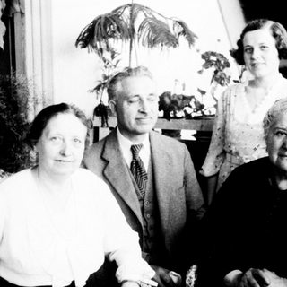 Four elderly individuals posing indoors together.