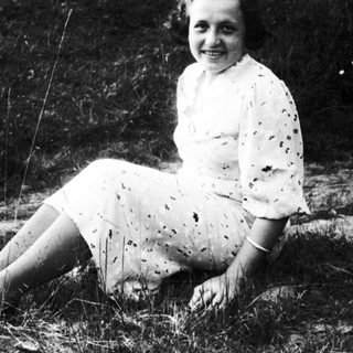 Young woman smiling outdoors in vintage dress.