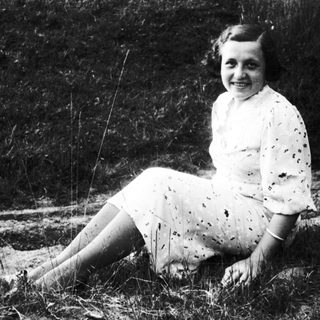 Young woman smiling outdoors in vintage dress.