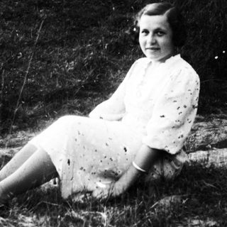Young girl sitting outdoors in vintage dress.