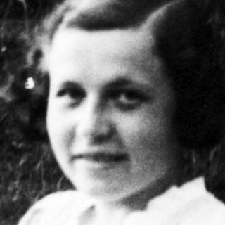 Young girl sitting outdoors in vintage dress.