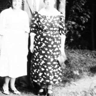 Four people posing outdoors in formal attire.