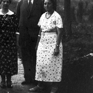 Four people posing outdoors in a wooded area.