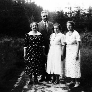 Family portrait outdoors in vintage clothing, early 20th century.
