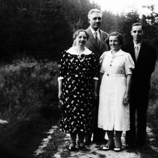 Family portrait outdoors in early 20th-century clothing.
