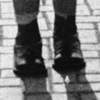 Child in vintage school outfit standing outdoors.