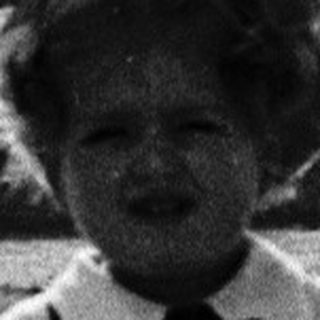 Child in vintage school outfit standing outdoors.