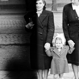 Three women in 1940s-era clothing walking outdoors together.