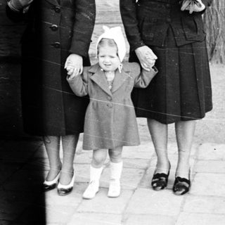 Three women in 1940s-era clothing walking outdoors together.