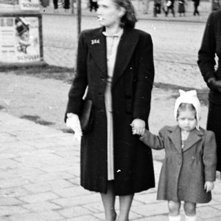 Three women walking outdoors holding hands.