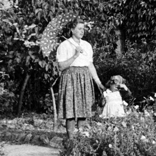 Vintage photo: Woman and child near traditional Japanese birdhouse.