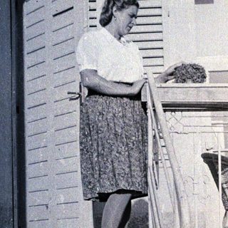 Woman standing on stairs reading letter.