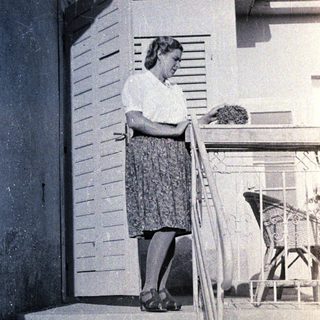 Woman standing on stairs reading letter.