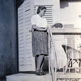 Woman standing on stairs reading letter.