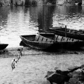 Historic bridge, river, and boats in Prague.