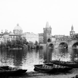 Historic stone bridge with boats on river.