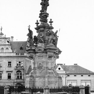 Baroque-style fountain monument with statues in urban setting.